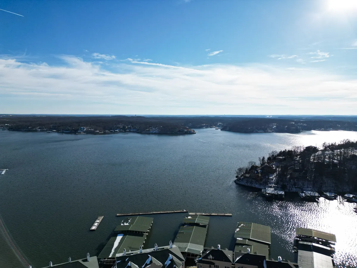 A sweeping view of the lake featuring marina docks and surrounding hills, illustrating the community’s direct access to water activities like boating and fishing. The expansive water view and marina infrastructure underscore possibilities for adventure and lake exploration.